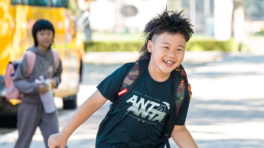 Happy boy arriving to school